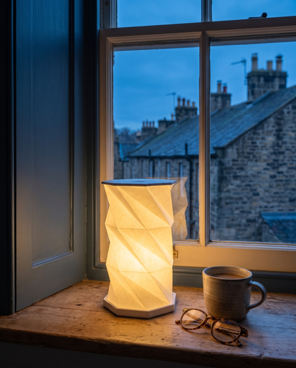 Lumina Fold lamp glowing cordless on a windowsill at dusk in a British home